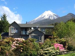 una casa con una montaña cubierta de nieve en el fondo en Georges BnB Nature and Lifestyle Retreat, en New Plymouth