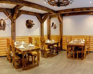 a dining room with wooden tables and chairs at Forest House in Tatariv