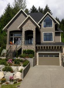 a house with a driveway and a garage at Nature's Door Guest Suite in Port Moody