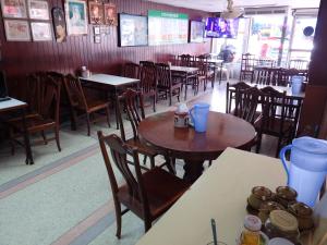 a dining room with tables and chairs in a restaurant at Sakol Hotel in Nakhon Ratchasima