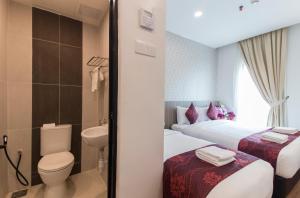 a bathroom with two beds and a toilet and a sink at Signature International Hotel China Town in Kuala Lumpur +71 photos