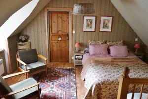 a bedroom with a bed and a chair in a attic at Le Triskelium in Landebaëron