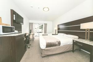 a hotel room with a large bed and a television at Airport Gateway Hotel in Auckland