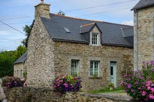 a stone house with flowers in front of it at Le Triskelium in Landebaëron