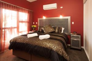 a bedroom with a large bed with red walls at Albany Waves in Albany +35 photos
