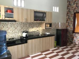 a kitchen with a counter and a refrigerator at Nariska Suite Homestay Lampung in Bandar Lampung