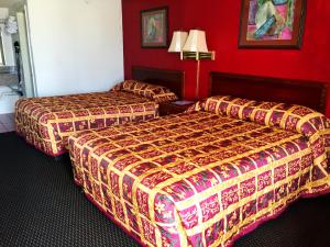 Dos camas en una habitación de hotel con paredes rojas. en Crown Inn Grand Prairie, en Grand Prairie 13 fotos más