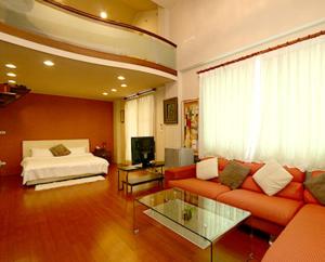 a living room with a couch and a bed at Star House in Tianfu