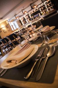 une table avec des ustensiles en argent sur une table dans l'établissement Hotel Eskualduna Chez Katina, à Saint-Martin-dʼArrossa