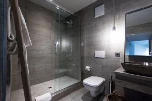 a bathroom with a shower, toilet, and sink at Seven Boutique Hotel in Ascona