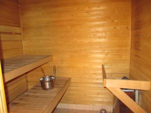 a small wooden sauna with a bucket in it at Lapin Kutsu Apartments in Saariselka