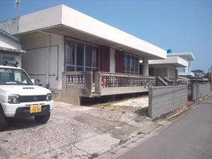 a white car parked in front of a house at Shirahono Yado Aoi Umi in Ishigaki Island
