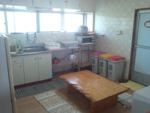 a kitchen with a sink and a table in it at Shirahono Yado Aoi Umi in Ishigaki Island