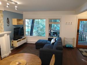 a living room with a couch and a tv at Coastal Fox Den in Sechelt