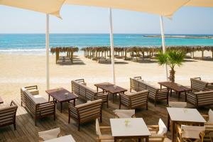 a restaurant on the beach with tables and chairs at Asterias Beach Hotel in Ayia Napa