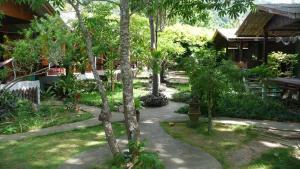 a path in a garden with trees and a building at Bamboo Bungalow - Thong Nai Pan Yai in Thong Nai Pan Yai