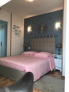 - une chambre avec un grand lit et un couvre-lit rose dans l'établissement La Grille Dorée, à Amboise