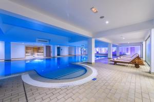 a swimming pool with a bench in a building at Asterias Beach Hotel in Ayia Napa