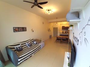 Bricks Homestay @ Cameron Highlands في مرتفعات كاميرون: غرفة معيشة مع أريكة ومروحة سقف