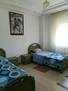 - une chambre avec 2 lits et une photo sur le mur dans l'établissement luxury family apartment in ain Zaghouan nord, à El Aouina