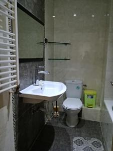 La salle de bains est pourvue d'un lavabo blanc et de toilettes. dans l'établissement luxury family apartment in ain Zaghouan nord, à El Aouina