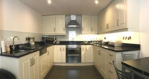 a kitchen with white cabinets and black counter tops at No. 14 in St. Andrews