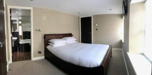 een slaapkamer met een groot bed en een badkamer bij No. 14 in St Andrews