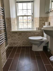a bathroom with a toilet and a sink and a window at No. 14 in St. Andrews