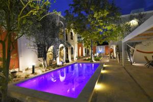 a swimming pool with purple lighting in front of a house at Casa Valladolid Boutique Hotel in Valladolid