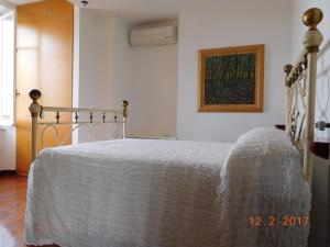 a bedroom with a bed with a white blanket at Casa Nori in Fezzano