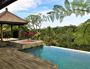 a swimming pool with a gazebo next to a resort at Ayuterra Resort in Ubud