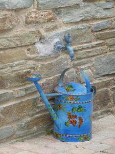 a blue bucket hooked to a wall with a faucet at Anastasia Luxury Villas in Gavrio