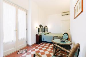 a bedroom with a bed and a table and a chair at Villino Eleonora in Parghelia +37 photos