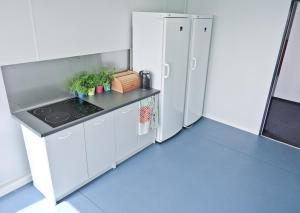 a kitchen with a stove and a refrigerator at Hostel Września in Września