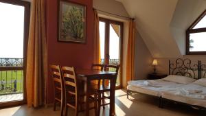 una camera da letto con un tavolo e un letto accanto a una finestra di Willa Dzika Róża a Sandomierz