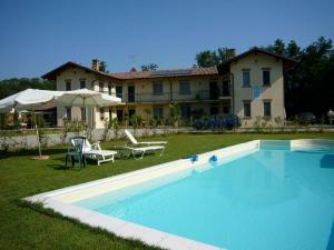 a large swimming pool in front of a house at Cascina Vignole in Montafia