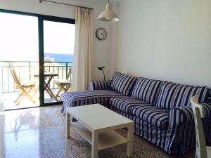 a living room with a striped couch and a table at Hola Apartments 14-3 in Playa de San Juan