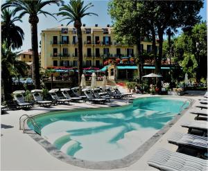 a swimming pool with chairs and a hotel in the background at Hotel Metropole in Santa Margherita Ligure