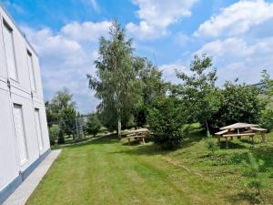 Un patio con dos mesas de picnic y árboles. en Hostel Września, en Września