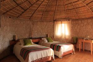 A bed or beds in a room at Ckamur Atacama Ethno Lodge & Spa