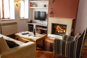 a living room with a fireplace and a tv at Casa Maitetxu in Puente la Reina