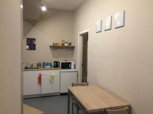 a small kitchen with a table and a microwave at Hostel Oras in Vilnius
