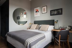 佛罗伦萨c-欢乐酒店的卧室里有一张床、一张书桌和一面镜子