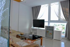 sala de estar blanca con TV y sofá en Cam Thanh Hotel, en Quảng Ngãi