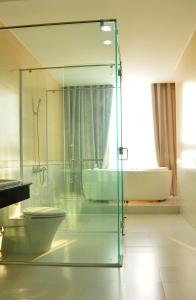 クアンガイにあるCam Thanh Hotelのバスルーム(ガラス張りのシャワー、トイレ、バスタブ付)