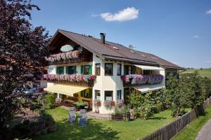 una casa con flores a un lado. en Gästehaus Alpina en Bad Kohlgrub