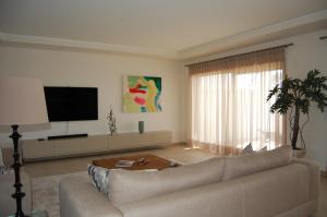 a living room with a couch and a flat screen tv at Villa Golf 6 in Óbidos