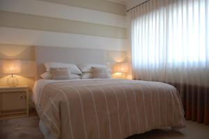 a bedroom with a large bed with white sheets and pillows at Villa Golf 6 in Óbidos