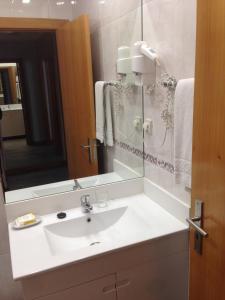 een badkamer met een witte wastafel en een spiegel bij Seculo apartments in Porto
