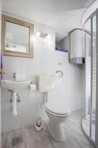 a white bathroom with a toilet and a sink at Studio Amore in Dubrovnik